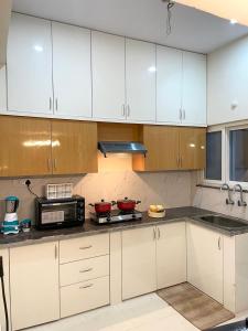 a kitchen with white cabinets and red bowls on the counter at Luxury Homes in Hyderabad