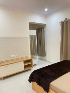 a bedroom with a bed and a dresser and a mirror at Luxury Homes in Hyderabad