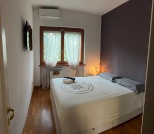 a bedroom with a large white bed with a window at Villa Domus Roma in Rome
