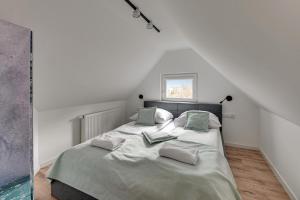 a bedroom with a bed with two pillows on it at Leśna bajka by Grand Apartments in Sopot