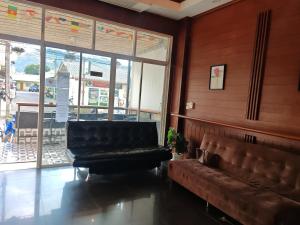 a waiting room with a leather couch and a window at TJ PATONG HOSTEL - Prime Location by OTOP Market & Sea in Patong Beach