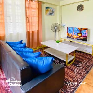 a living room with a leather couch and a table at 2-BR Narra Unit by The Pineview Chateau in Baguio