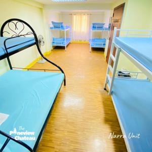a room with two bunk beds and a wooden floor at 2-BR Narra Unit by The Pineview Chateau in Baguio