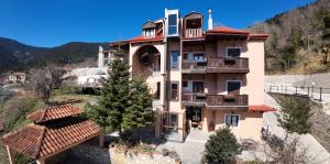 カルペニシにあるVilla Virginia Hotelの丘の上にバルコニー付きの大きなピンクの建物