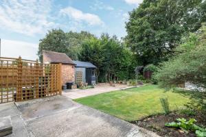 een tuin met een houten hek en een huis bij Lennox Road Small Rooms Inn in Bletchley