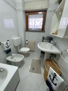 a bathroom with two sinks and a toilet and a sink at A due passi dal mare 2023 in Nettuno +36 photos