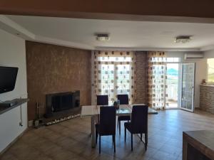 a living room with a table and chairs and a television at SeaViewPeramou in Elevtheraí