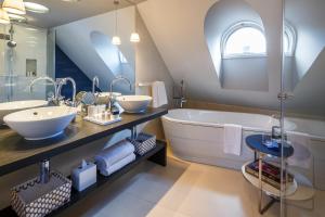 a bathroom with a large tub and two sinks and a large mirror at Hotel Seehof in Zurich