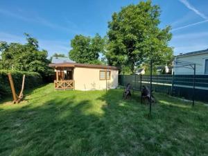 a small shed in a yard with two chairs at Domek letniskowy ,,Jolczyn'' in Nowęcin