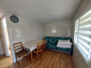 a room with a table and chairs and a couch at Domek letniskowy ,,Jolczyn'' in Nowęcin