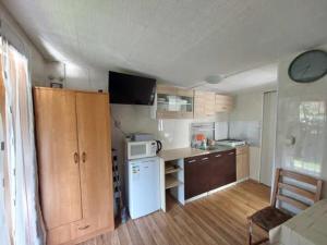 a kitchen with a white refrigerator and a white microwave at Domek letniskowy ,,Jolczyn'' in Nowęcin