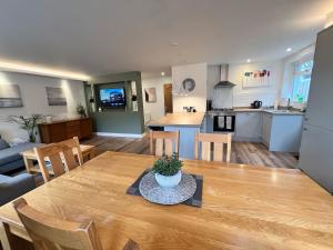 a kitchen and living room with a wooden table and chairs at Holiday Bungalow in Arnside in Arnside