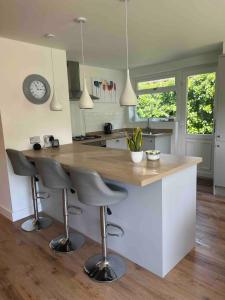 a kitchen with a counter and two bar stools at Holiday Bungalow in Arnside in Arnside
