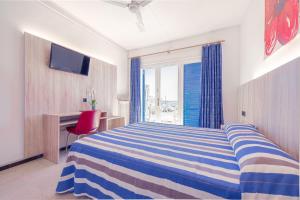a bedroom with a bed and a desk and a window at Hotel Bell Aire in L'Estartit