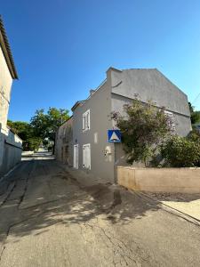 ノヴァリャにあるMimis Apartmentsの灰色の建物前空き通り