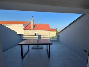 a table on a balcony with a view of a building at Mimis Apartments in Novalja