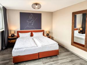 a bedroom with a bed and a mirror at Geräumige Ferienwohnung mit Parkplatz direkt an der S-Bahn nach München in Unterschleißheim