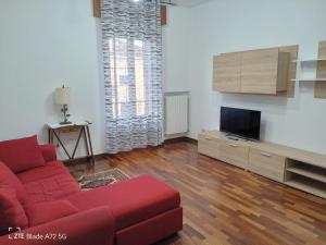 a living room with a red couch and a flat screen tv at Gladys in Pesaro