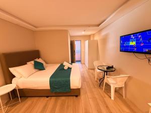 a hotel room with a bed and a flat screen tv at Marco Polo Motor Inn Sydney Hotel in Sydney