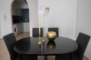a black dining room table with a lamp on it at Thalia's Holiday Apartment in Tala Chorio in Tala