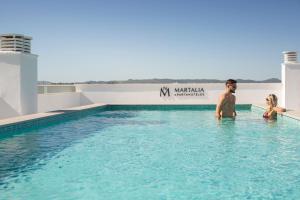 a man and a woman standing in the water in a swimming pool at Apartamentos Martalia Arenal in Ronda
