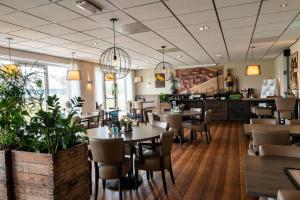 um restaurante com mesas e cadeiras e um balcão em Hotel B&B d'Olde Smidse em Giethoorn