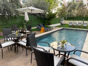a patio with tables and chairs next to a pool at Sorta Hotel in Antalya