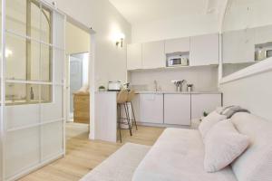 a white living room with a couch and a kitchen at Luxury Suite Spa Bath & Cinema Screen- Bordeaux in Bordeaux