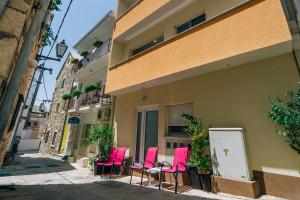 a group of pink chairs sitting outside of a building at Luxur house with seaview teracce in Baška Voda