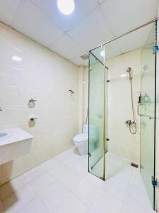 une salle de bain avec une douche en verre et des toilettes dans l'établissement Khách Sạn Phú Thành 1 Hotel Đà Lạt, à Đà Lạt