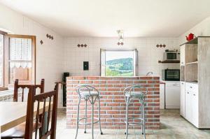 a kitchen with a brick wall and stools in it at Cosy House in Isongo in Isongo