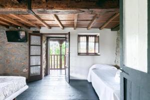 a room with two beds and an open door at Cosy House in Isongo in Isongo