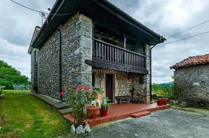 a stone house with a porch and a balcony at Cosy House in Isongo in Isongo