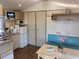 a small kitchen and dining room with a table at Mobile-home camping 7 fonts AGDE in Agde