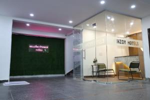 a lobby with two chairs and a large glass wall at Innzoy Hotels - TNGO Colony in Hyderabad