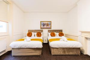 two beds with teddy bears on them in a room at Mayfair Residences in London