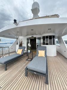 een dek van een jacht met twee stoelen en een tafel bij Riva 130 in Cannes +11 foto's