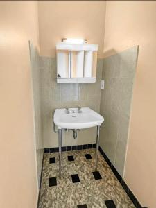 een badkamer met een witte wastafel en een tegelvloer bij La maison du bonheur à Talloires in Talloires