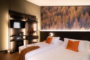 ein Schlafzimmer mit zwei Betten und einem Gemälde an der Wand in der Unterkunft Hotel Due Cime in Forni di Sopra