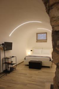 a bedroom with a bed and a television in it at La Moretta Suite rustic apartment in Negrar
