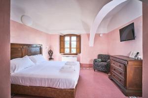 皮恩扎Monastero Sant'Anna in Camprena的一间带床、电视和椅子的卧室 更多37张照片