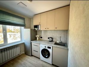 a kitchen with a washing machine and a sink at Квартира 4-40 in Balqash +3 photos