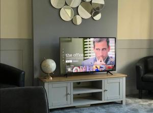 Televiisor ja/või meelelahutuskeskus majutusasutuses The Tudors Modern 3-Bed Home with Fast WiFi, Private Drive & Near Town Center