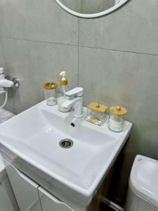 a white sink in a bathroom with a mirror at Квартира 4-40 in Balqash
