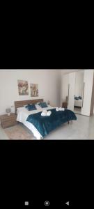 a bedroom with a large bed with a blue blanket at White Lotus in Ribera +4 photos