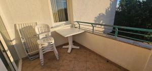 a balcony with two chairs and a table and a window at Apartment Astella 4 with Balcony and Pool in Pješčana Uvala  +3 photos