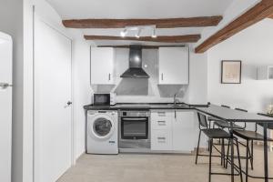 a kitchen with a stove and a washing machine at Alcoy Old Town - Reformed Penthouse with AC and wifi in Alcoy