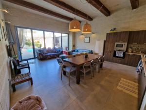 a living room with a dining table and a kitchen at Sunflower Farmhouse, Xewkija, Gozo in Xewkija