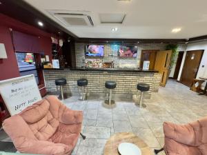 un bar con sedie e bancone con TV di Epsilon Hotel a Londra