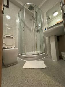 un bagno con doccia, WC e lavandino di Epsilon Hotel a Londra Altre 29 foto